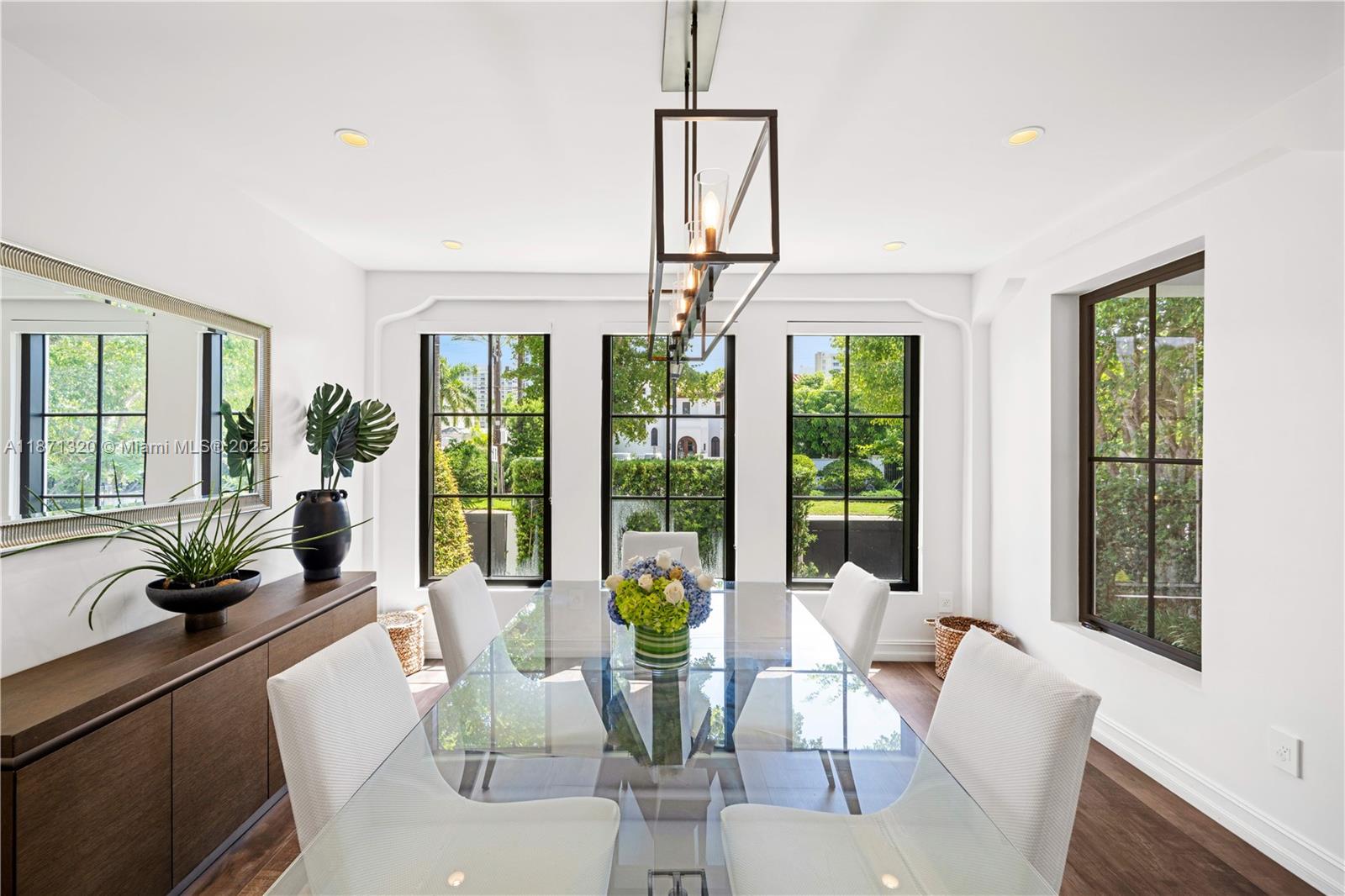 5728 Pine Tree Drive Miami Beach, FL 33140 - Photo 16 of 49 a view of a dining room with furniture large windows and wooden floor