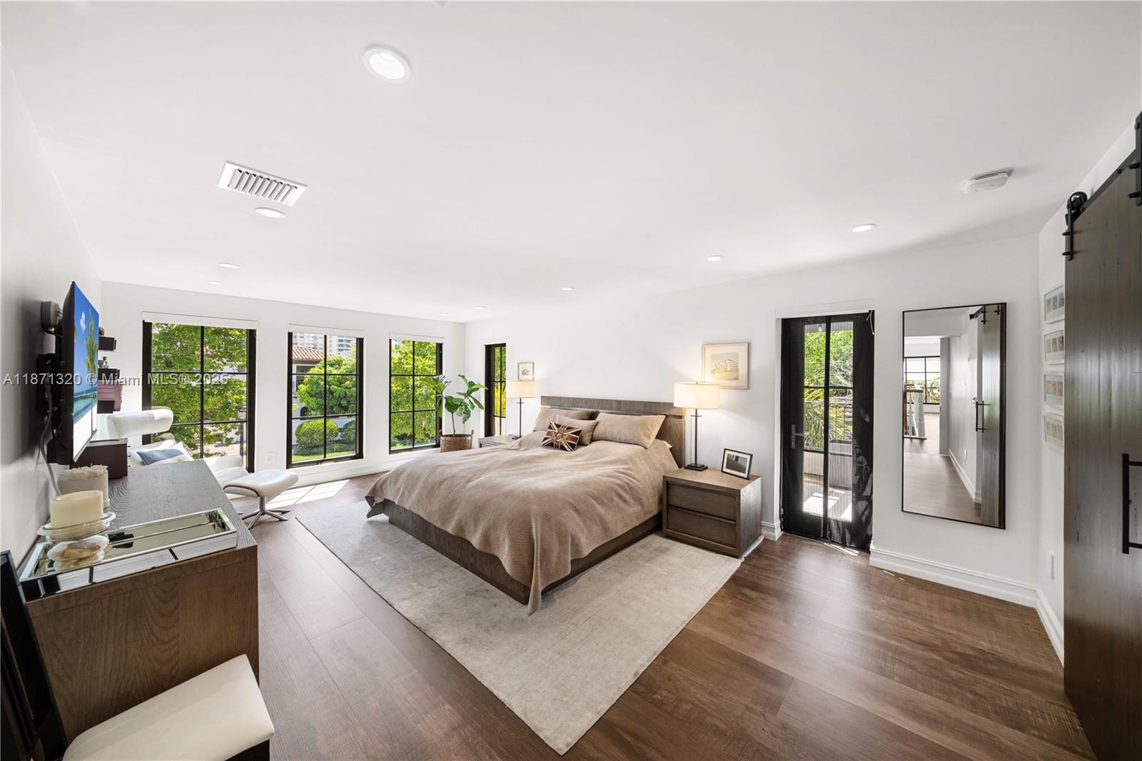 5728 Pine Tree Drive Miami Beach, FL 33140 - Photo 20 of 49 a bedroom with a large bed and a large window