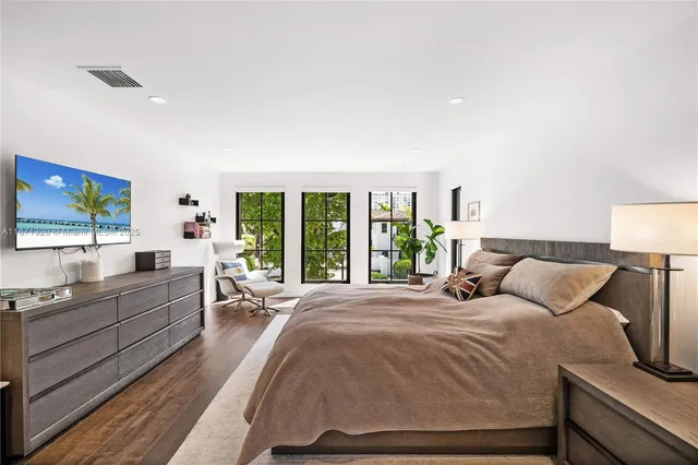 a spacious bedroom with a large bed and a wooden floor