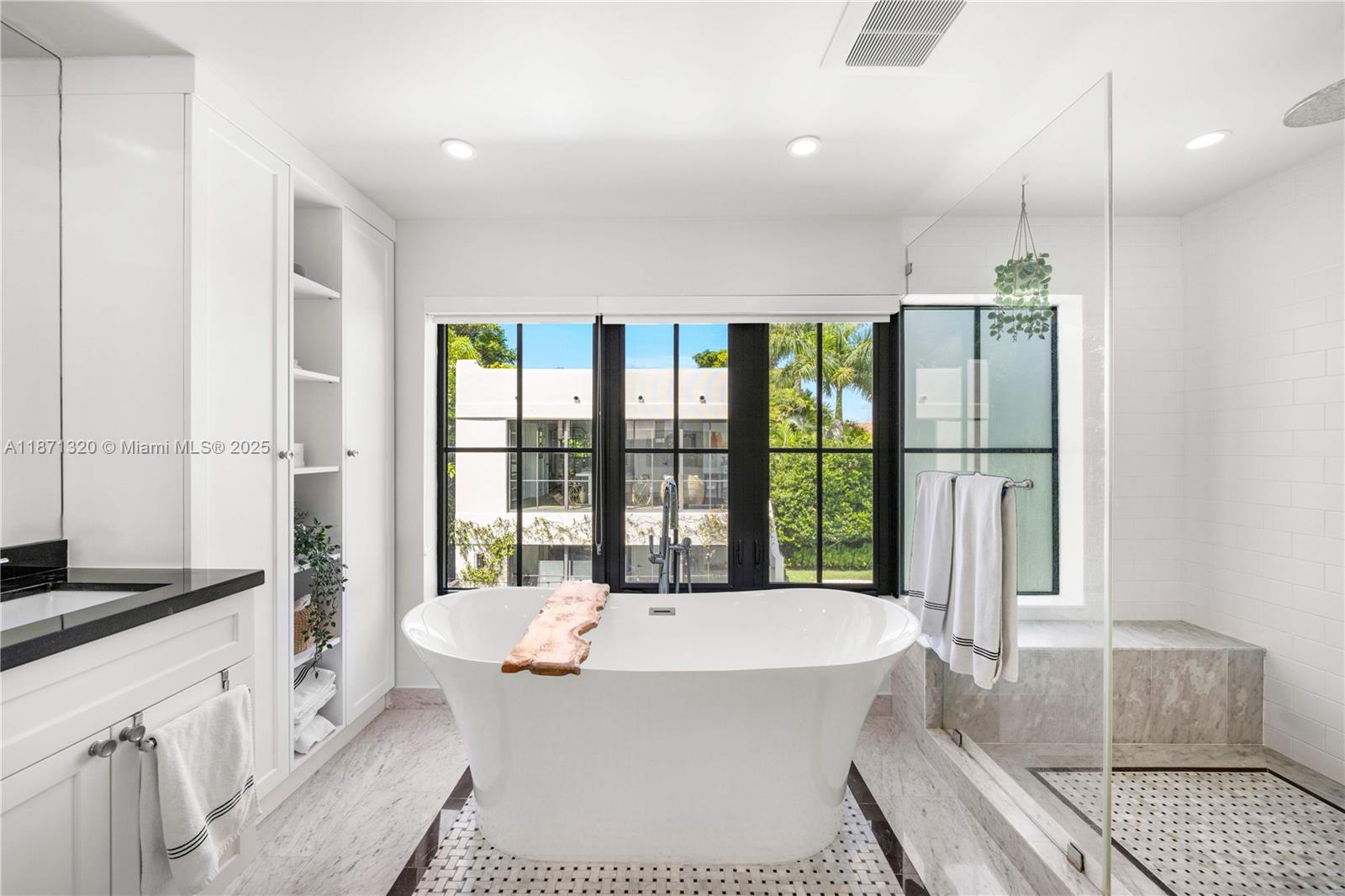 5728 Pine Tree Drive Miami Beach, FL 33140 - Photo 24 of 49 a spacious bedroom with a large bed and a large window