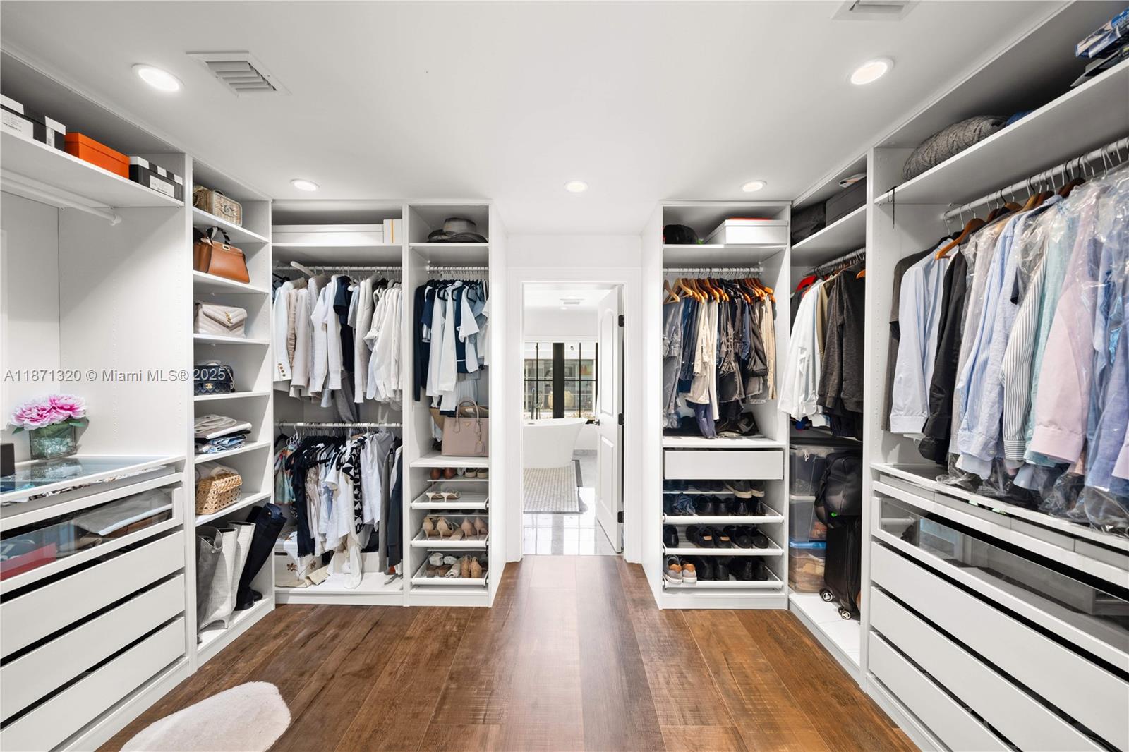 5728 Pine Tree Drive Miami Beach, FL 33140 - Photo 25 of 49 a view of walk in closet with wooden floor and windows