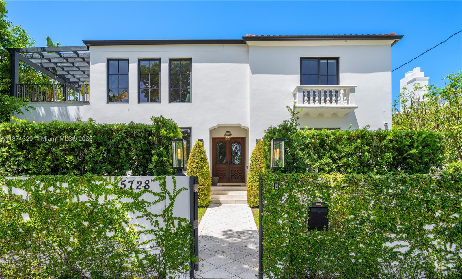 5728 Pine Tree Drive Miami Beach, FL 33140 - Photo 3 of 49 a front view of a house with garden