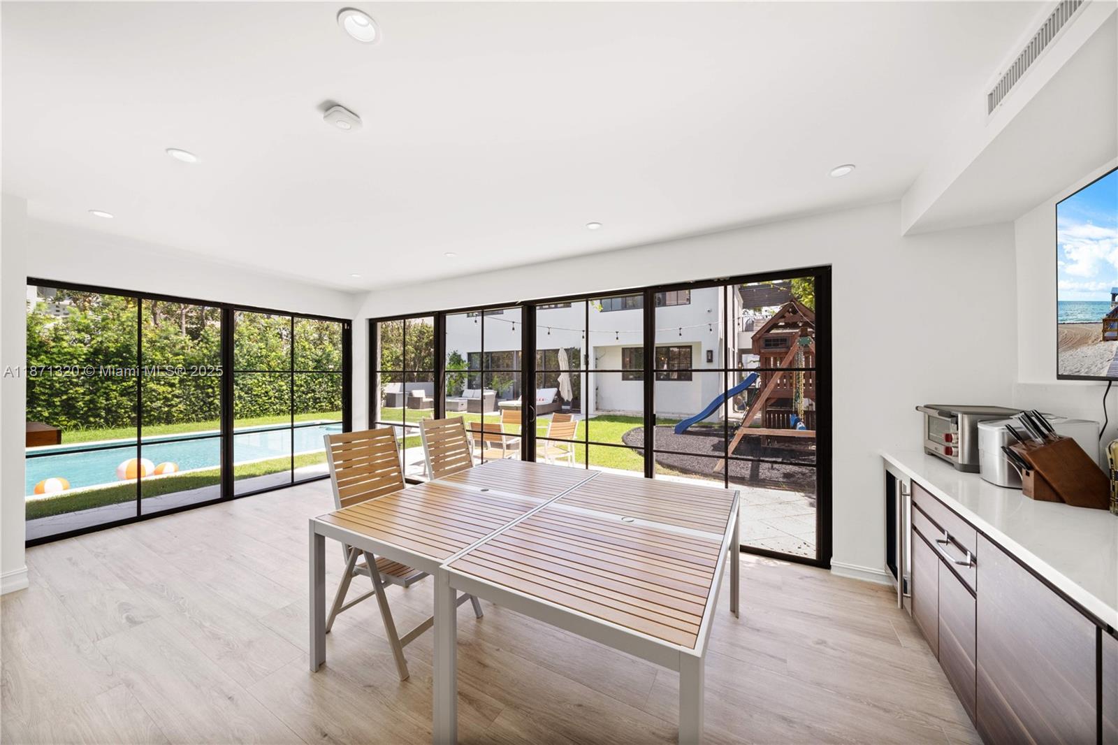 5728 Pine Tree Drive Miami Beach, FL 33140 - Photo 37 of 49 a living room with furniture and a flat screen tv