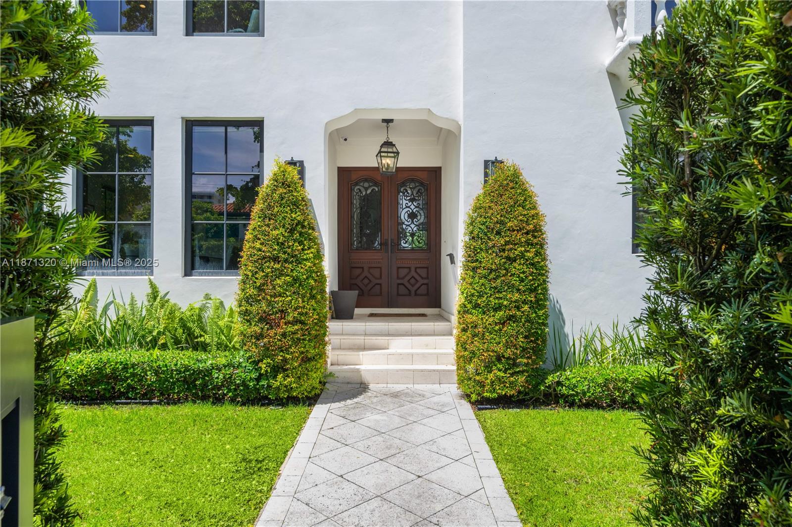 5728 Pine Tree Drive Miami Beach, FL 33140 - Photo 4 of 49 a front view of a house with garden