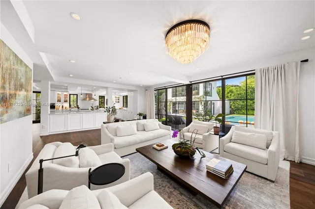 a living room with furniture a flat screen tv and a large window
