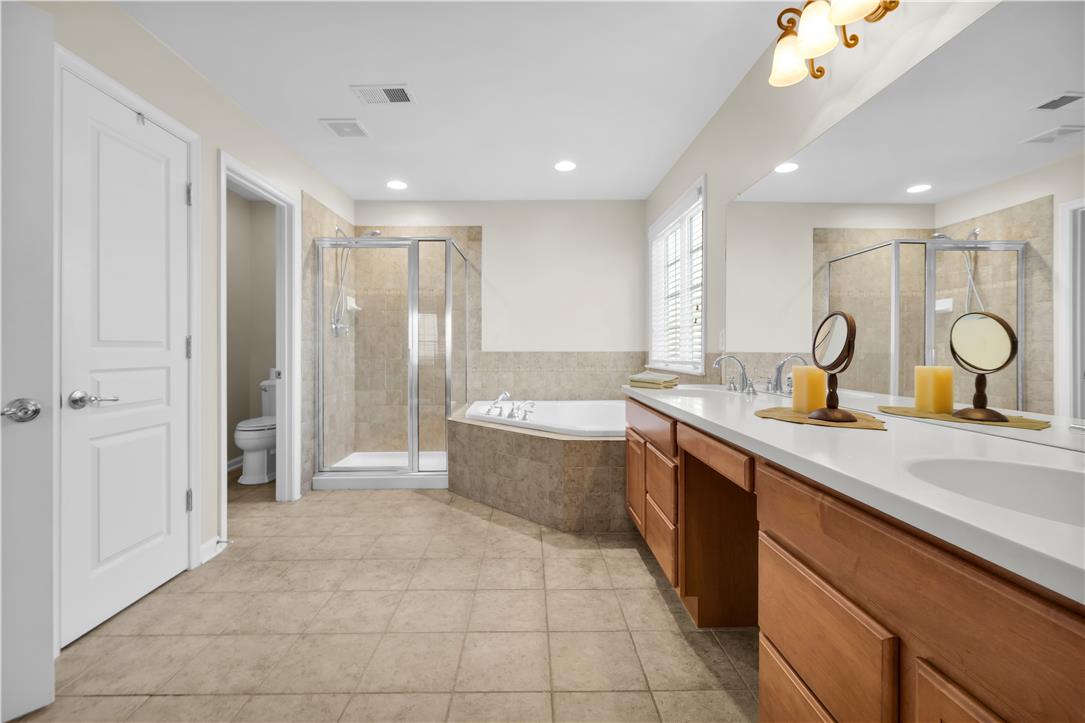 1709 Travers Road Breinigsville, PA 18031 - Photo 33 of 55 Indulge in a tranquil retreat featuring a spacious dual vanity, glass-enclosed shower, and deep soaking tub.