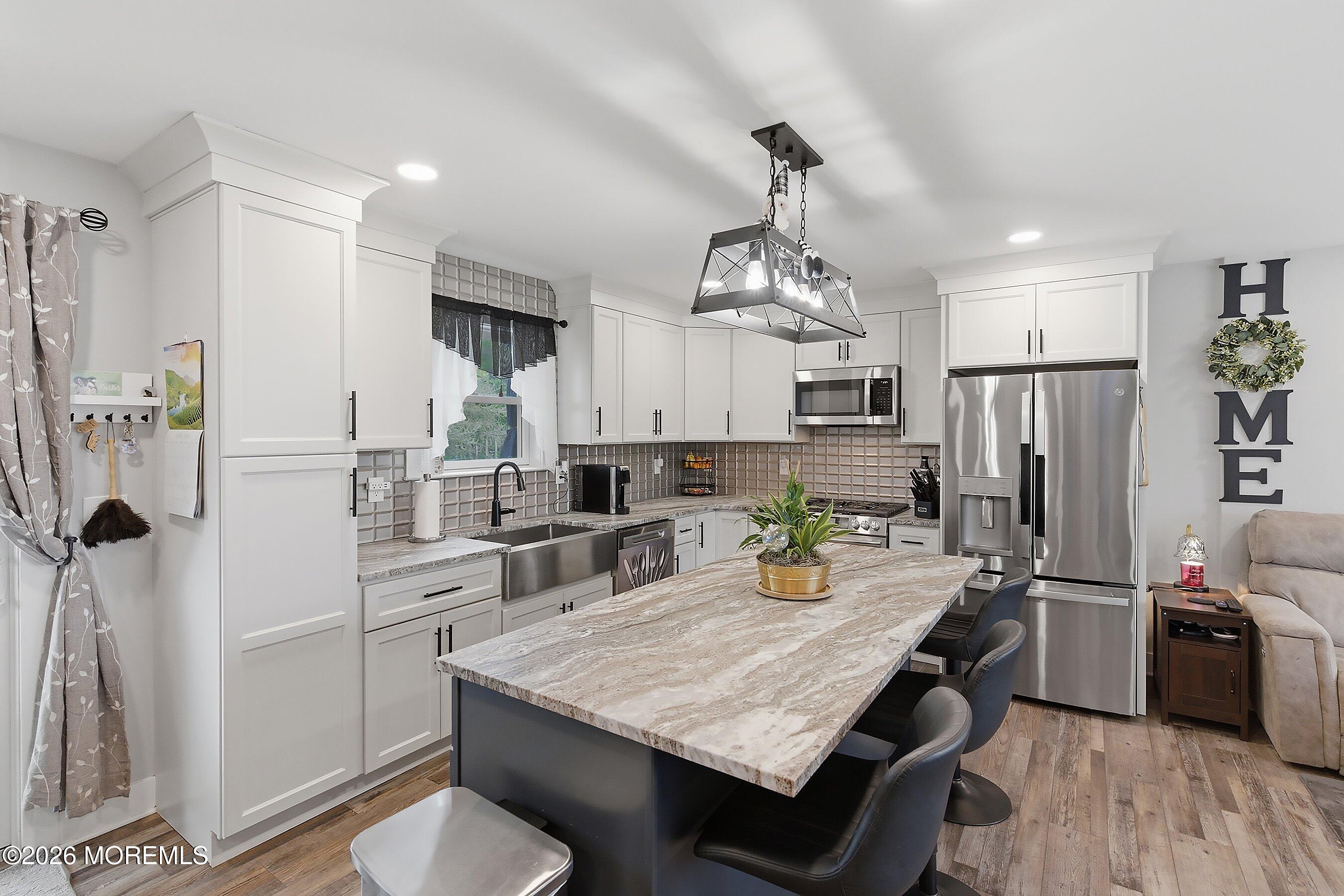 83 Whitesville Road Jackson, NJ 08527 - Photo 6 of 31 a kitchen with refrigerator cabinets and wooden floor