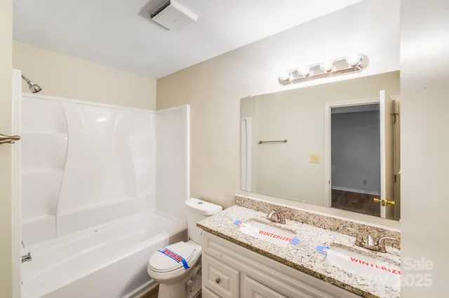 a view of an empty room with wooden floor and a ceiling fan