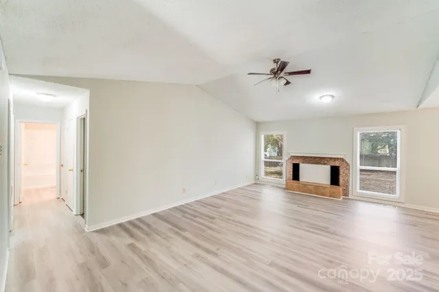 a view of a livingroom with wooden floor and a kitchen space