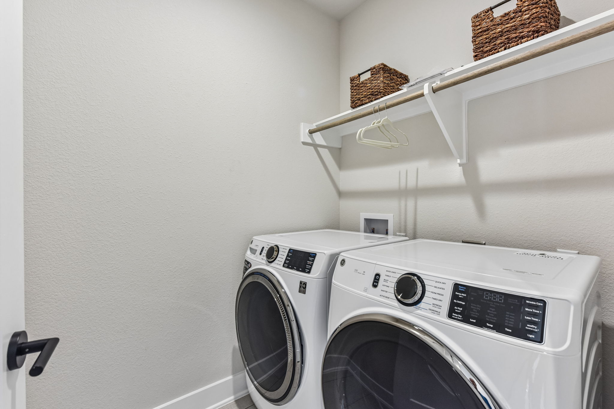 9101 Cattle Baron Path Austin, TX 78747 - Photo 18 of 40 Functional laundry room equipped with a convenient hanging rod and overhead shelf.