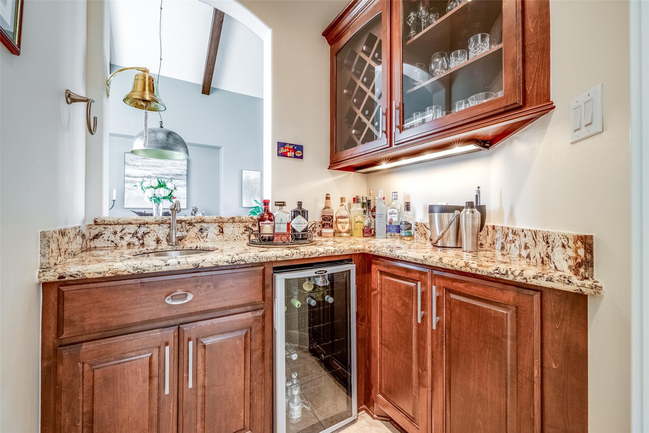31102 Lower Oxbow Trace Fulshear, TX 77441 - Photo 18 of 50 Wine room with lots of cabinets, sink, wine refrigerator, granite counter open through to the dining room
