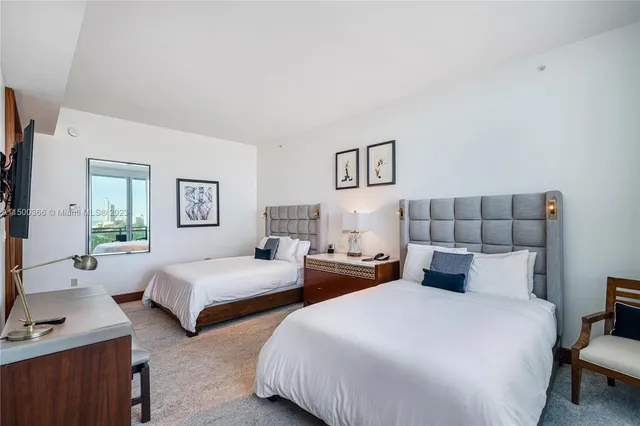 a bedroom with two beds and painting on the wall