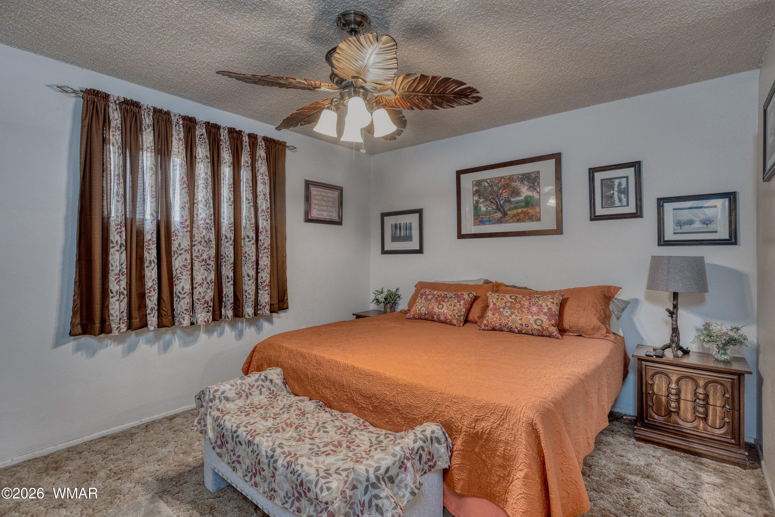 1114 Ranch Road Taylor, AZ 85939 - Photo 20 of 32 a bedroom with a large bed and a chandelier