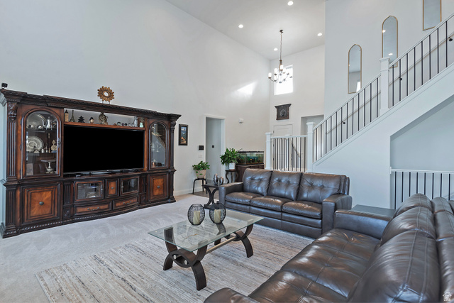 11694 Engelmann Drive Draper, UT 84020 - Photo 12 of 41 Living room featuring carpet flooring, a high ceiling, and a chandelier
