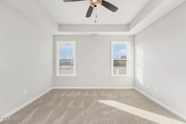 a bedroom with a large bed and a flat tv screen on dresser