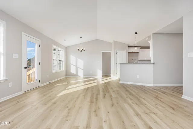 a view of empty room with wooden floor and window