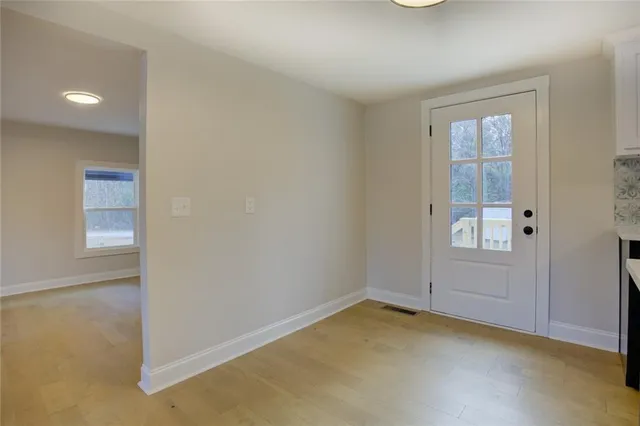 a kitchen with stainless steel appliances granite countertop a stove a sink a refrigerator and white cabinets