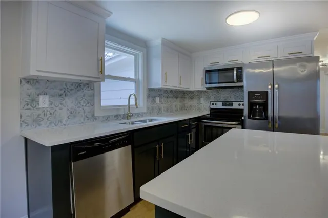 a kitchen with a sink a counter space and cabinets
