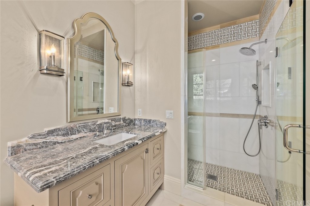 230 San Miguel Drive Arcadia, CA 91007 - Photo 32 of 57 a bathroom with a granite countertop sink a mirror and a shower