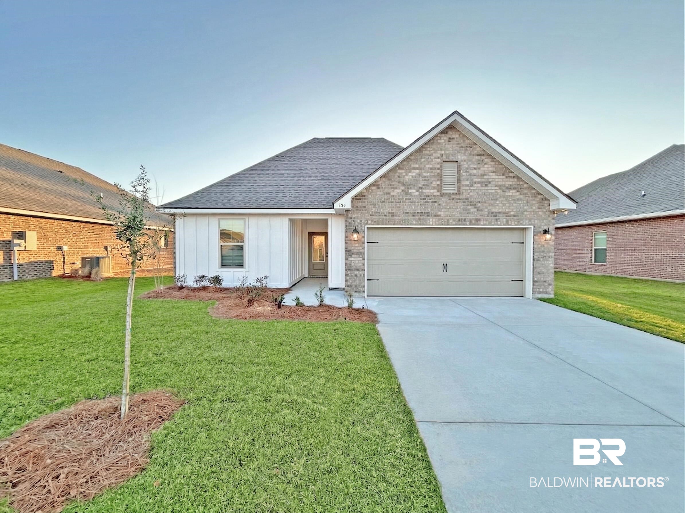 1744 Breckinridge Place Foley, AL 36535 - Photo 1 of 26 View of front of house with a front yard, driveway, a garage, brick siding, and board and batten siding