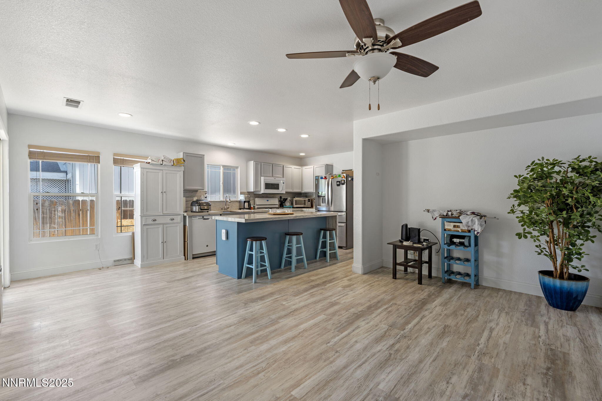 7721 Welsh Drive Reno, NV 89506 - Photo 13 of 27 a open kitchen with kitchen island a refrigerator a stove a dining table and chairs with wooden floor