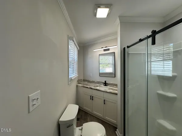 a bathroom with a granite countertop toilet sink and mirror