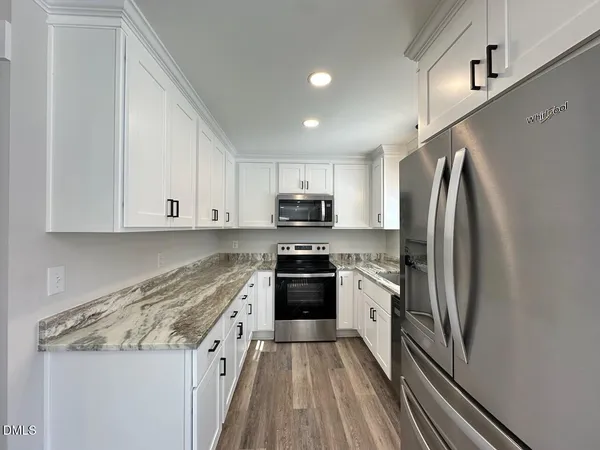 a kitchen with granite countertop stainless steel appliances and wooden cabinets