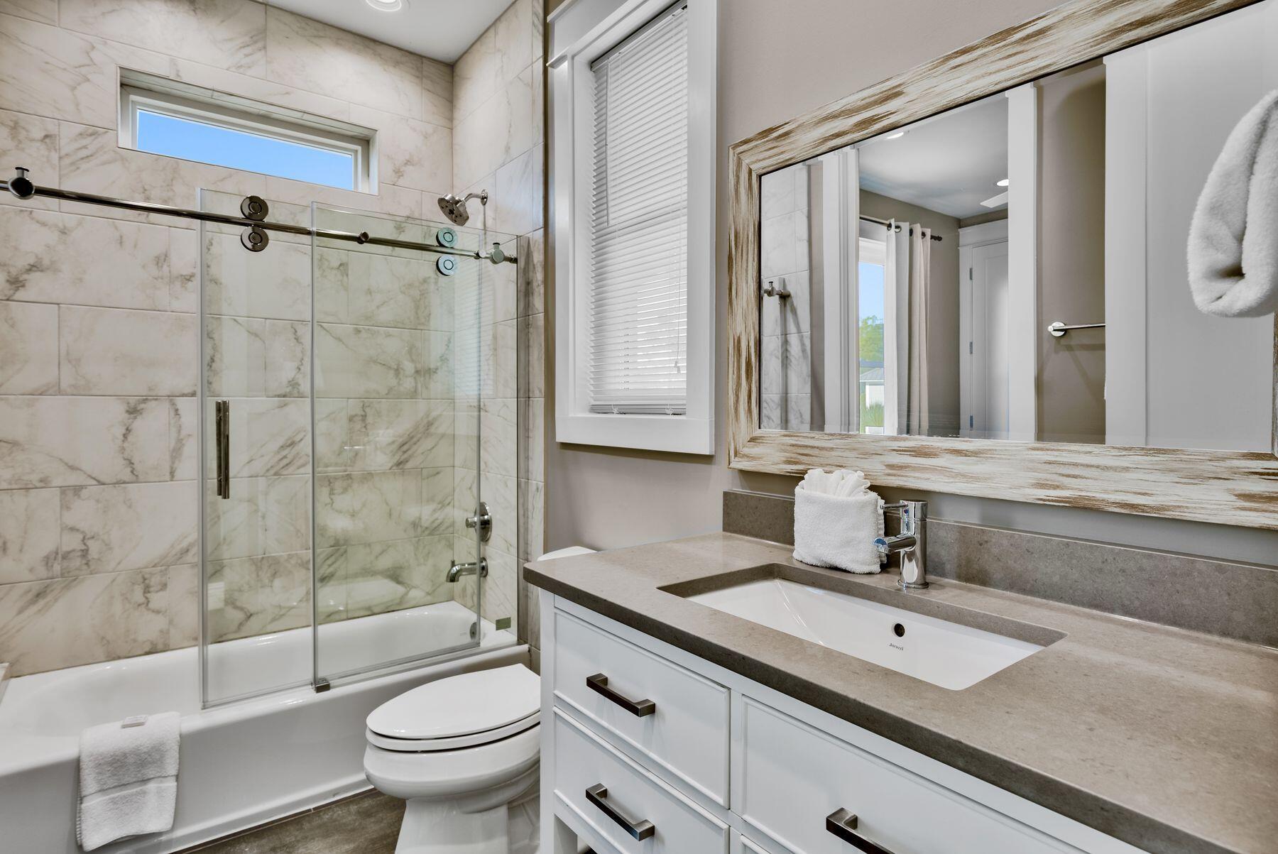 106 St Simon Circle Miramar Beach, FL 32550 - Photo 17 of 27 a bathroom with a granite countertop sink a toilet a mirror and shower