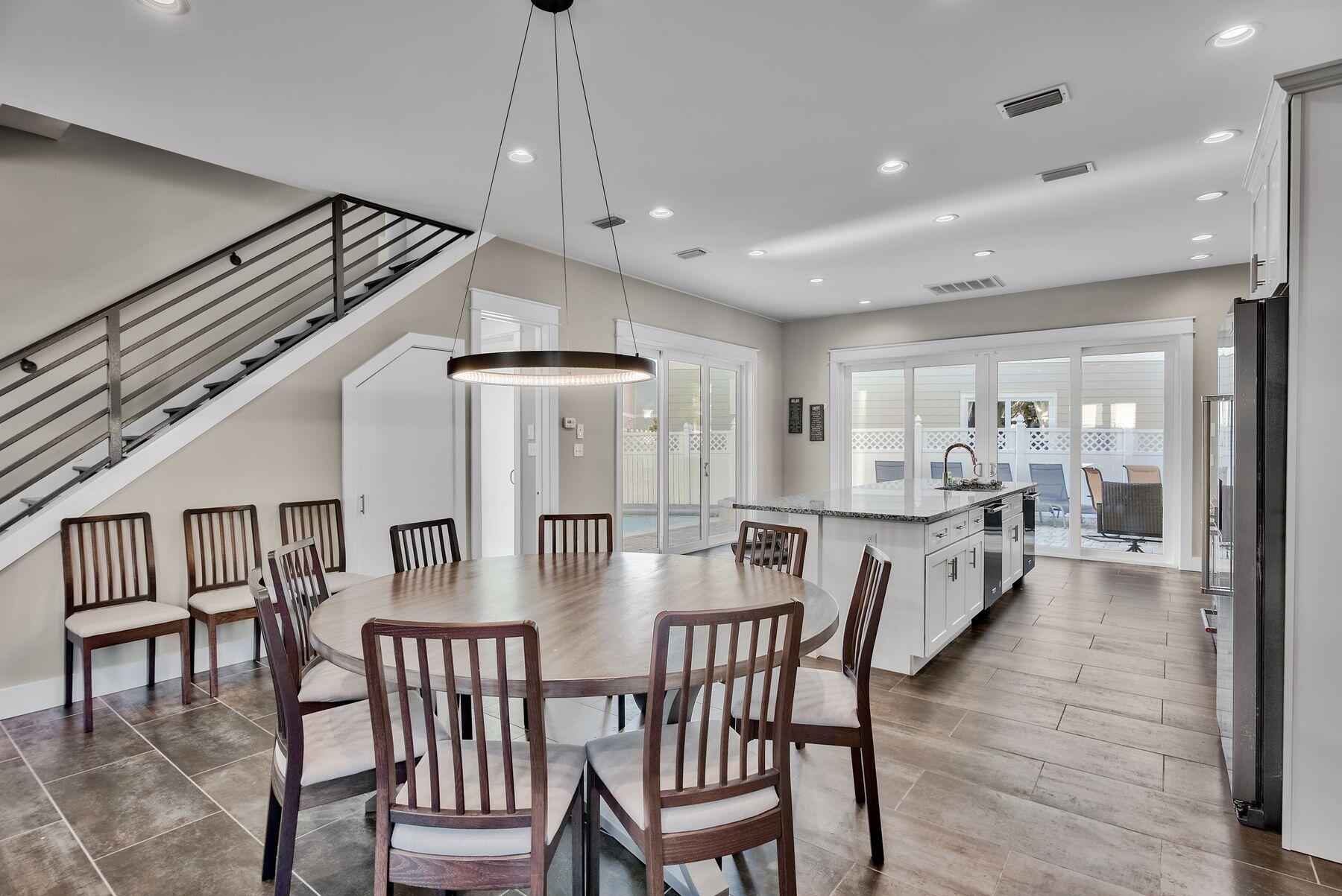 106 St Simon Circle Miramar Beach, FL 32550 - Photo 7 of 27 a view of a dining room and livingroom with furniture wooden floor a rug a flat screen tv a painting and a chandelier
