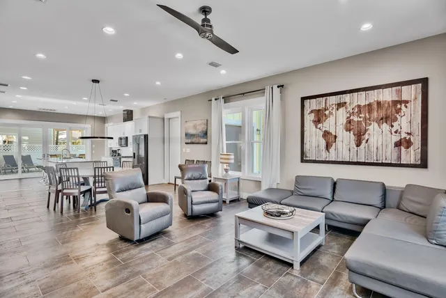 a living room with furniture kitchen view and a large window