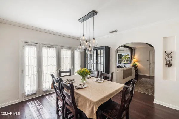 a view of a a dining room with furniture window and wooden floor