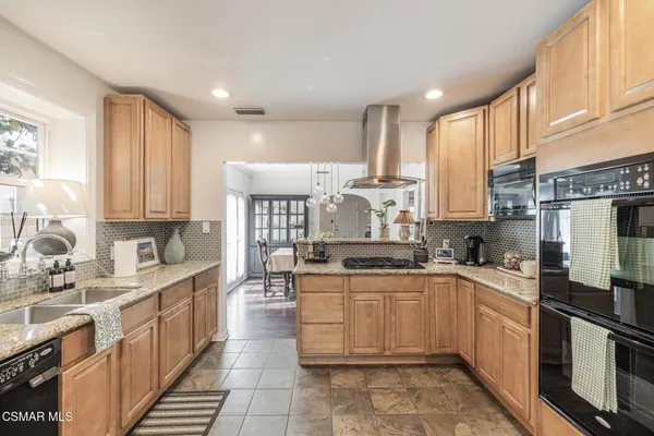a kitchen with stainless steel appliances a sink stove top oven and cabinets