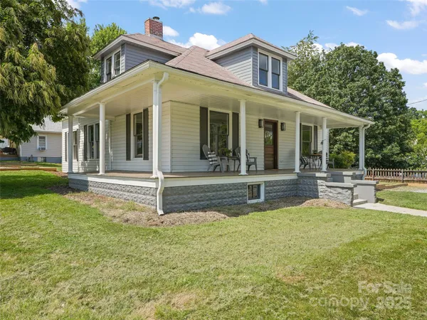 a view of house with a yard and sitting area
