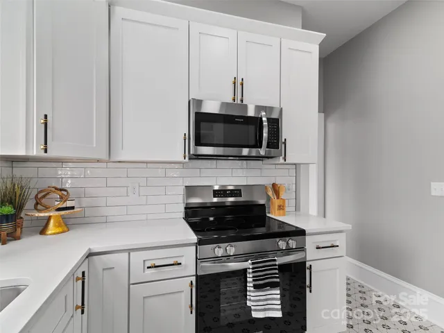 a kitchen with a stove and a white cabinets