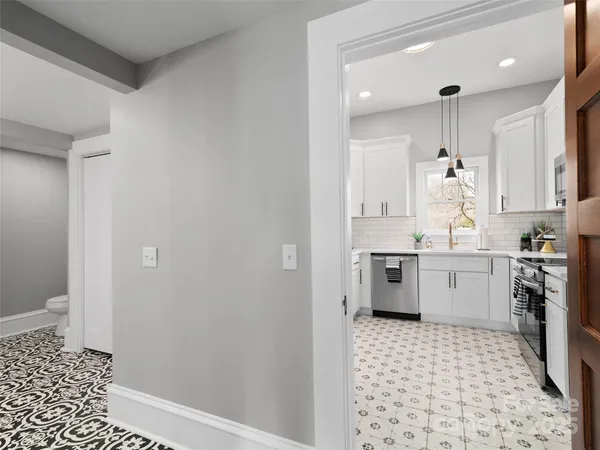a kitchen with a sink a stove cabinets and wooden floor