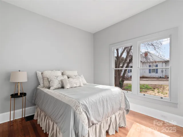 a bedroom with a bed and a large window