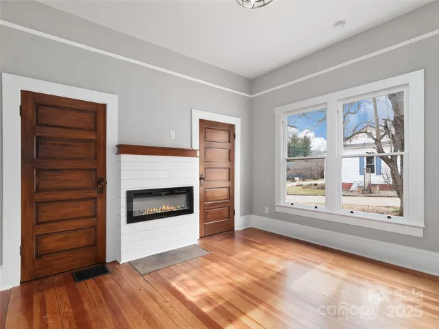 a view of an empty room with a fireplace and a window