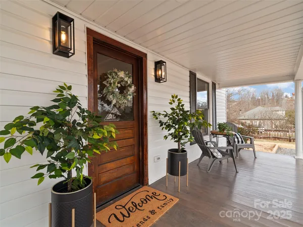 a dining room with furniture potted plants and wooden floor