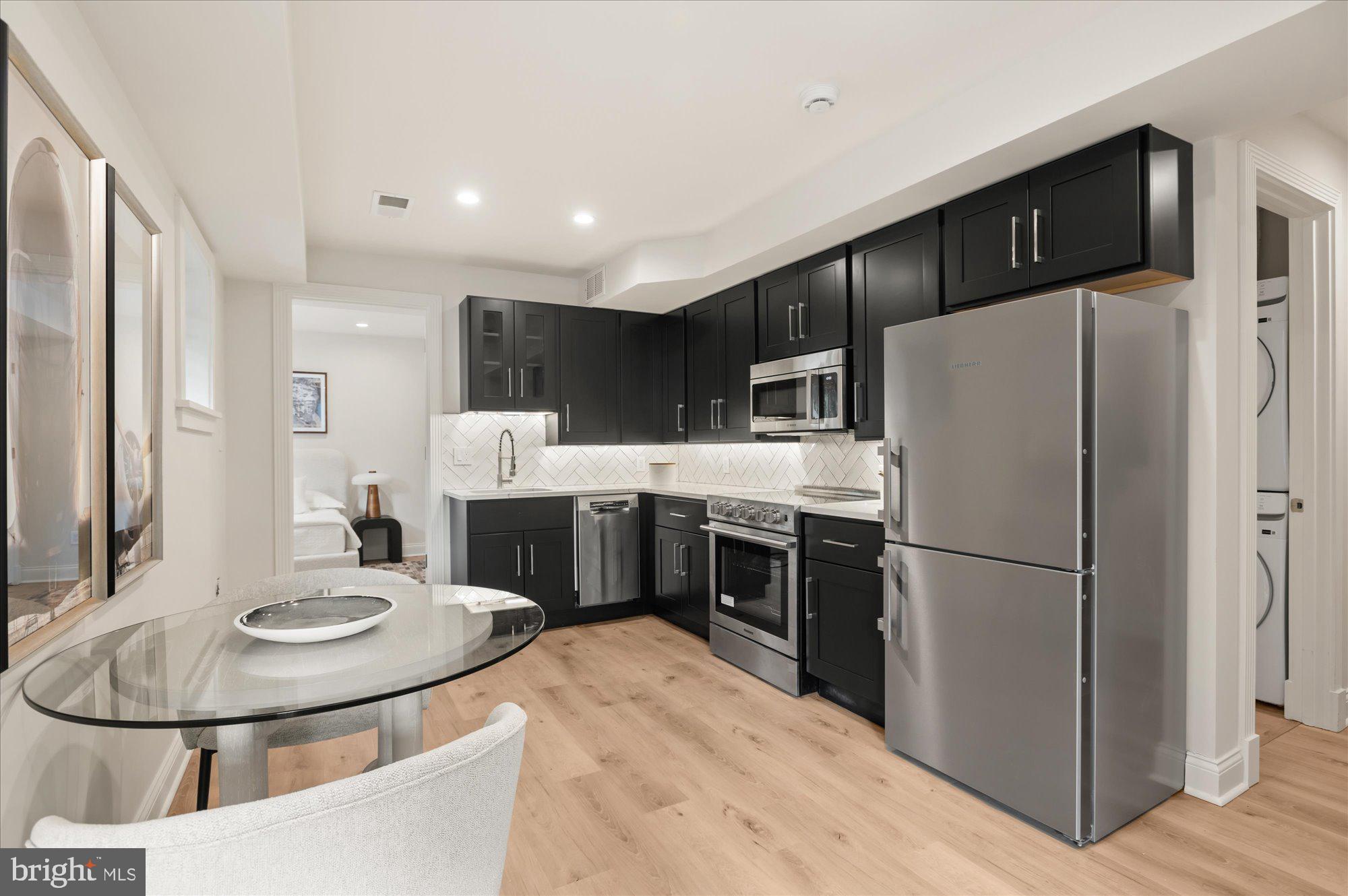 1115 Rhode Island Avenue Northwest Washington, DC 20005 - Photo 72 of 81 a kitchen with stainless steel appliances a refrigerator a stove a sink a dining table and chairs