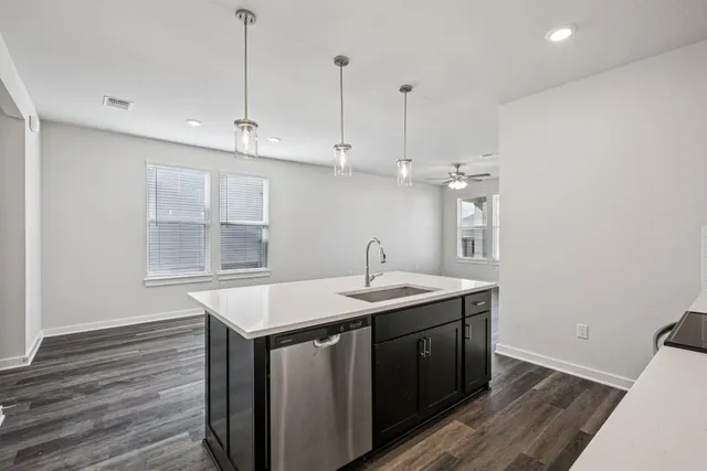 a kitchen with a sink a window and wooden floor