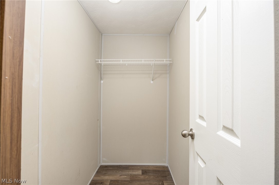 7455 Stanleyville Road Whipple, OH 45788 - Photo 21 of 37 Interior closet with wire shelving system, wood-finish flooring, and a white paneled door with brushed nickel hardware