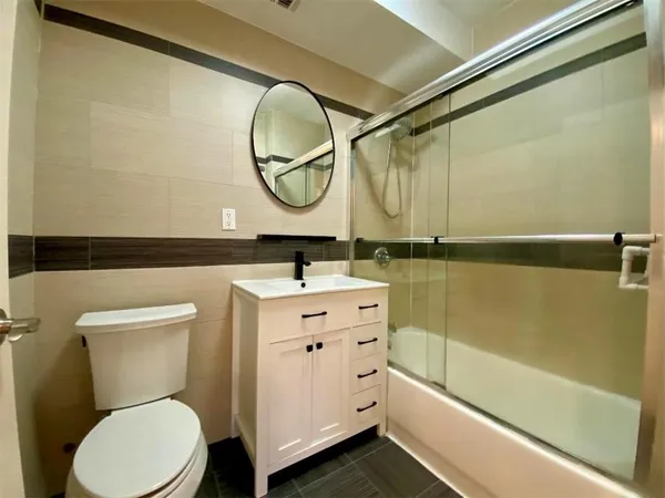 a bathroom with a sink mirror vanity and toilet