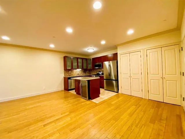 a kitchen with stainless steel appliances kitchen island a refrigerator a stove top oven and a ocean view