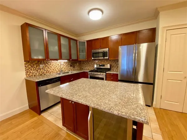 a kitchen with stainless steel appliances granite countertop a sink stove and refrigerator