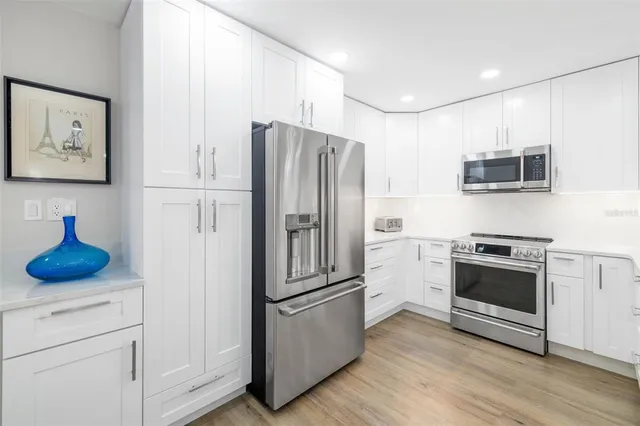 a kitchen with stainless steel appliances a refrigerator stove and microwave