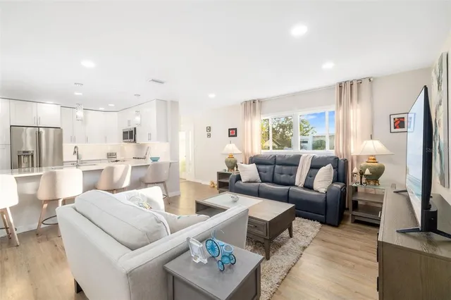 a living room with furniture kitchen view and a window