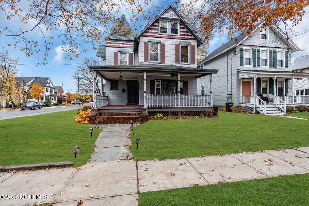 a front view of a house with a garden and trees