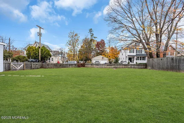 a front view of a house with a garden and trees