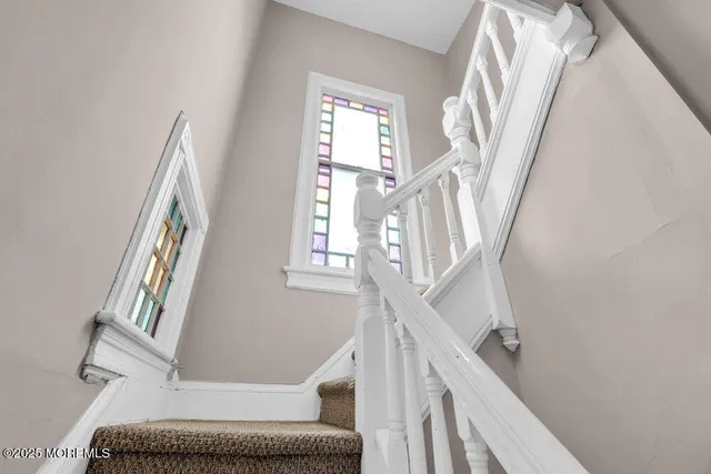 a view of staircase with wooden floor and a rug