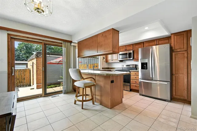 a kitchen with kitchen island a counter top space cabinets and stainless steel appliances